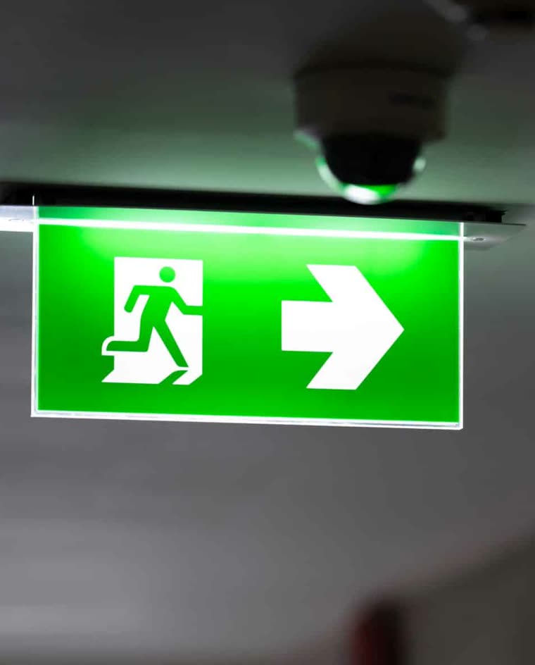 Illuminated green emergency exit sign in a corridor