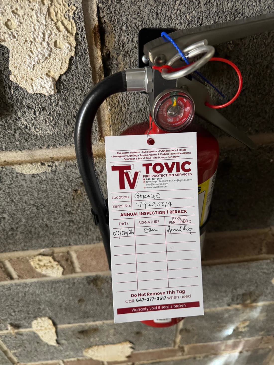 Tovic Fire annual inspection tag on a serviced fire extinguisher